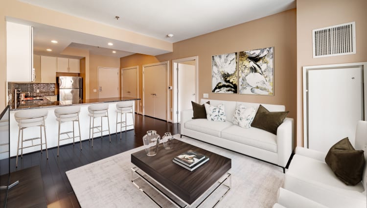 A furnished living room and bar seating at the kitchen peninsula in an apartment at Front Street Lofts in Hartford, Connecticut