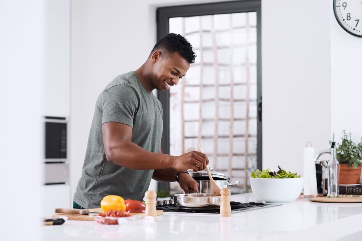 A resident enjoys his energy-efficient kitchen at Los Robles Apartments, Thousand Oaks, California