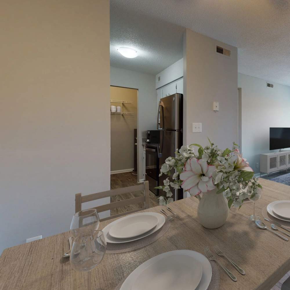 Dining area with a dining table and a view of fridge from the kitchen at Northwoods Apartments in Clarksville, Tennessee