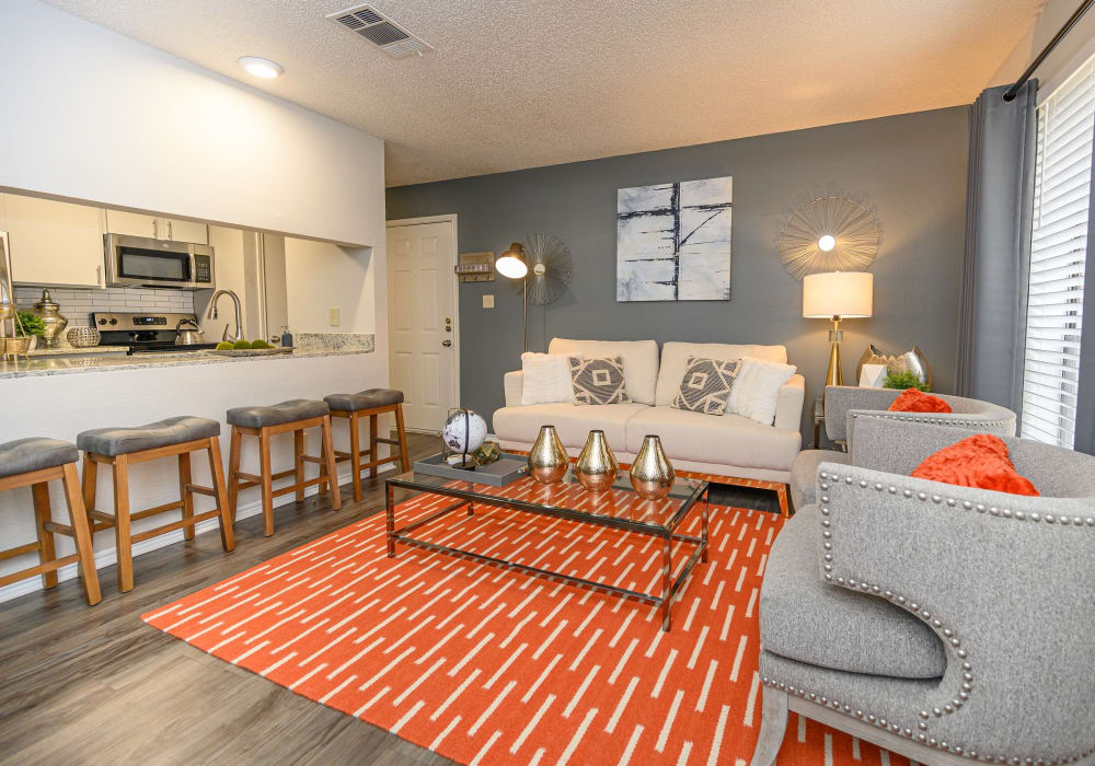 Well-decorated living room and kitchen in a model home at The Logan in Bedford, Texas
