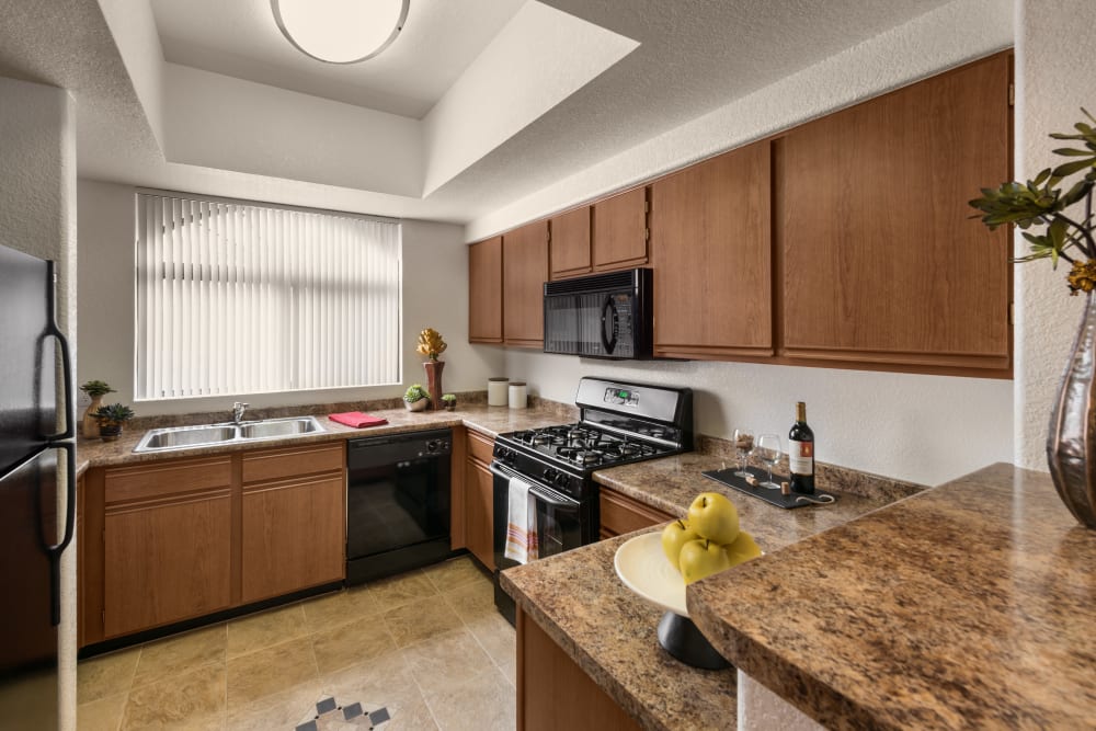 Gourmet kitchen with granite countertops in model home at San Prado in Glendale, Arizona