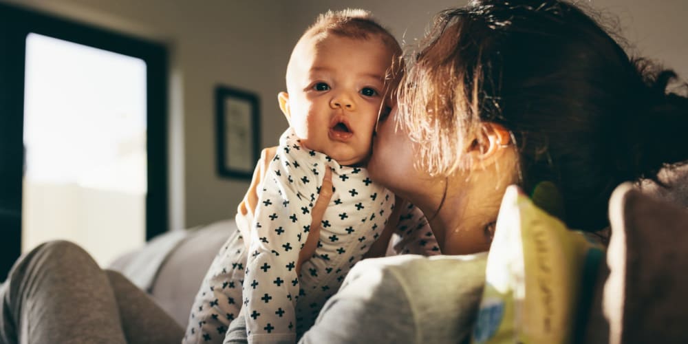 A new mother holds her baby at Farmhouse Row by Vintage, Mill Creek, Washington