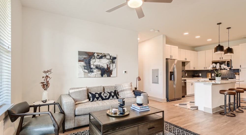 A furnished apartment living room and bar seating in the kitchen at Cypress McKinney Falls in Austin, Texas