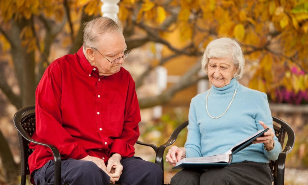 Resident couple reading a book at White Oaks in Lawton, Michigan