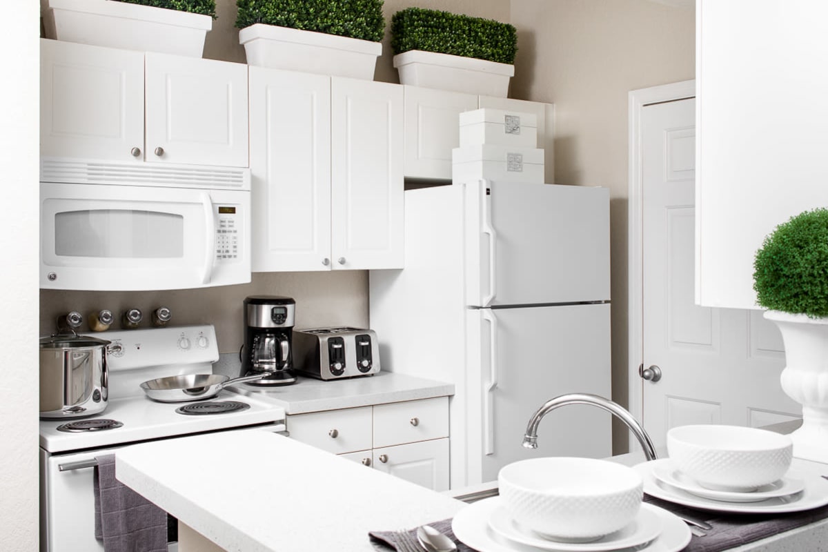 Very modern looking kitchen with white cabinets and appliances at The Ivy in Tampa, Florida