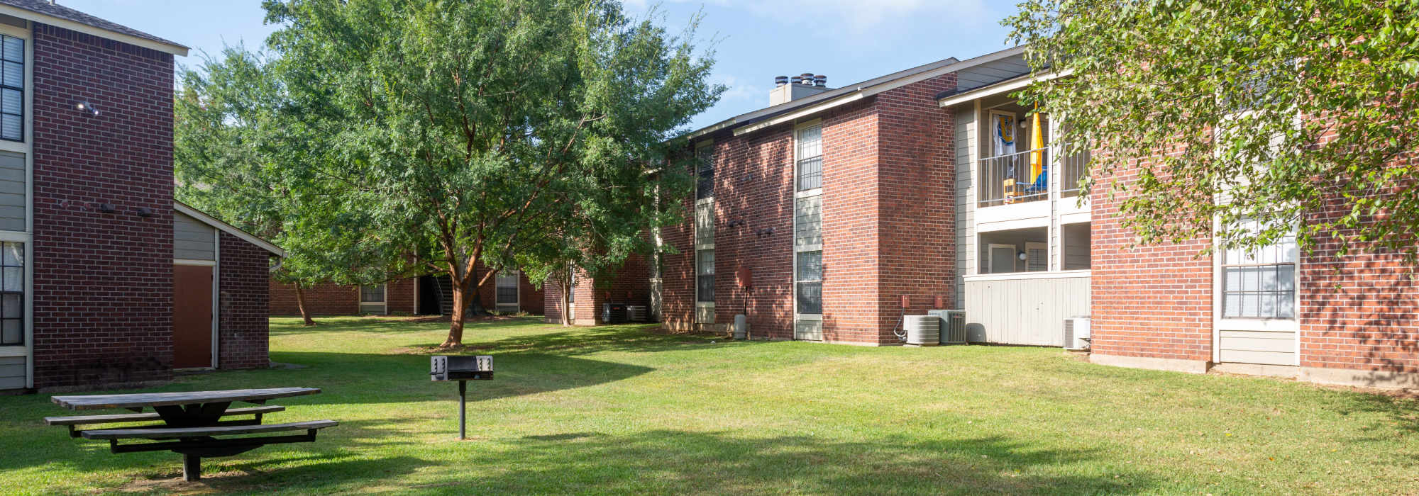 Exterior view surrounded by large grassy area at Southwood Village in Shreveport, Louisiana