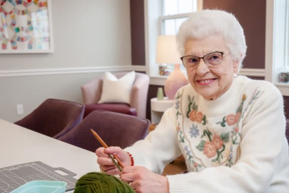 A smiling resident knitting at Mercer Hill at Doylestown in Doylestown, Pennsylvania