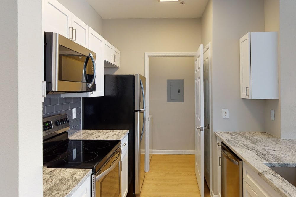 Kitchen with appliances and white cabinets at Highlands at Alexander Pointe in Charlotte, North Carolina