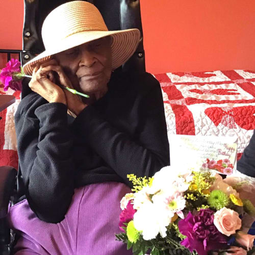 Resident being given a bouquet of flowers at Oxford Glen Memory Care at Grand Prairie in Grand Prairie, Texas
