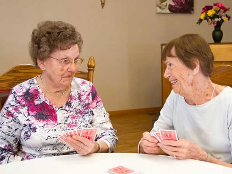 Two Residents playing cards together at Garden Place Red Bud in Red Bud, Illinois