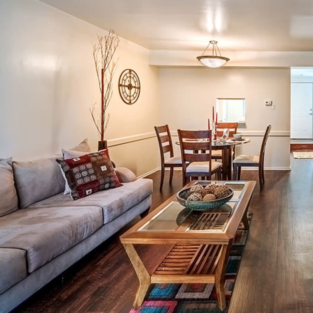 Model living room and dining area with hardwood-style flooring at The Cascades Townhomes and Apartments in Pittsburgh, Pennsylvania