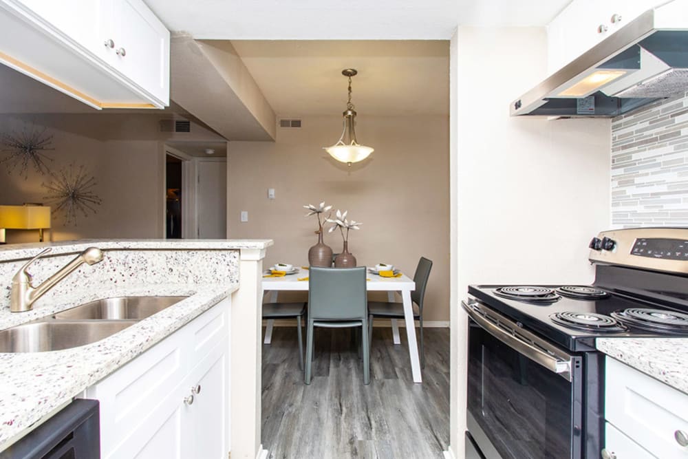 Fully equipped kitchen opening onto a dining area in a model home at Castlegate Collier Hills in Atlanta, Georgia