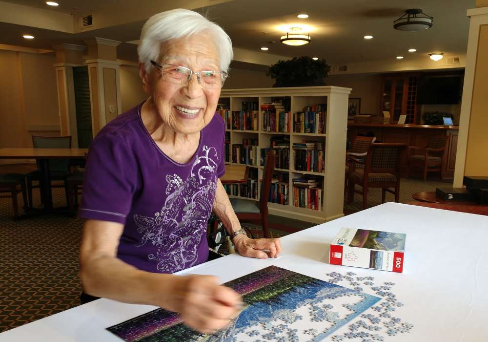 Resident working on a puzzle at Merrill Gardens at Santa Maria in Santa Maria, California