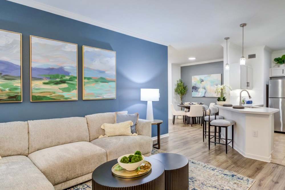Living area with sofa and wall art at The Abbey at Park Lakes in Humble, Texas