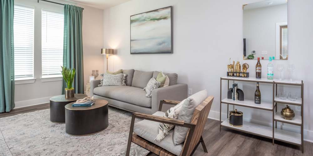 Modern living room with wood style flooring, couches and window access at Proximity New Bern in New Bern, North Carolina