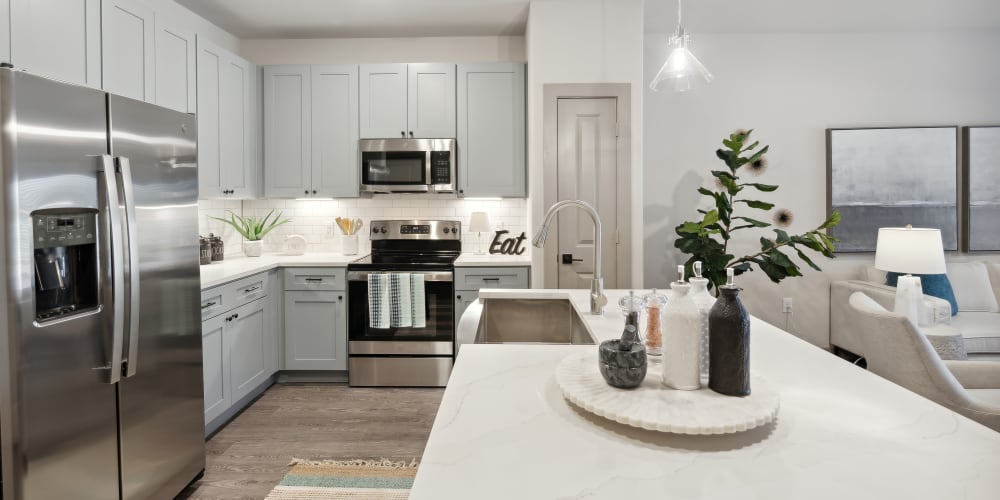 Kitchen with quartz countertops, a side-by-side refrigerator, and faux stainless-steel appliances at Radius Wolf Ranch in Georgetown, Texas