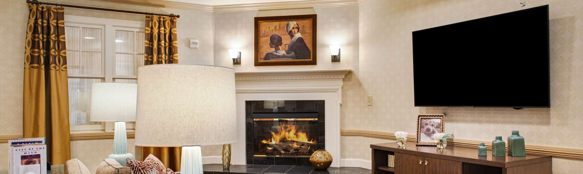 Cozy lounge with fireplace and comfortable seating at Glenncrest at Johns Creek in Johns Creek, Georgia