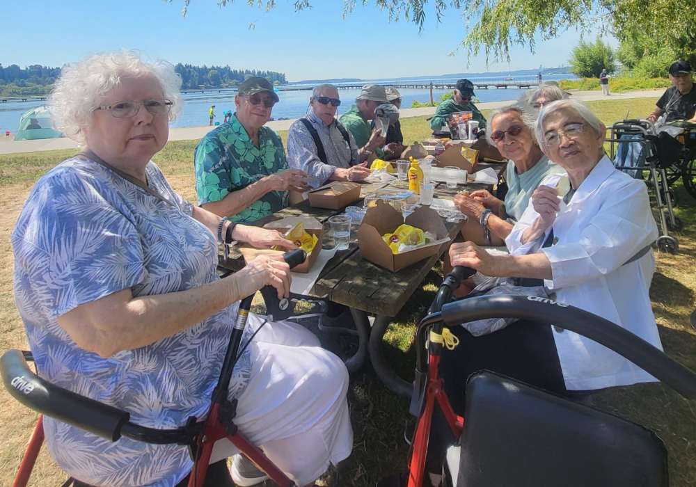 Residents having a picnic near Merrill Gardens at The University in Seattle, Washington