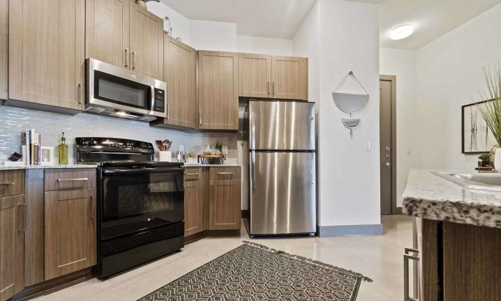 Bright kitchen with range and refrigerator at Millennium Place in Corinth, Texas