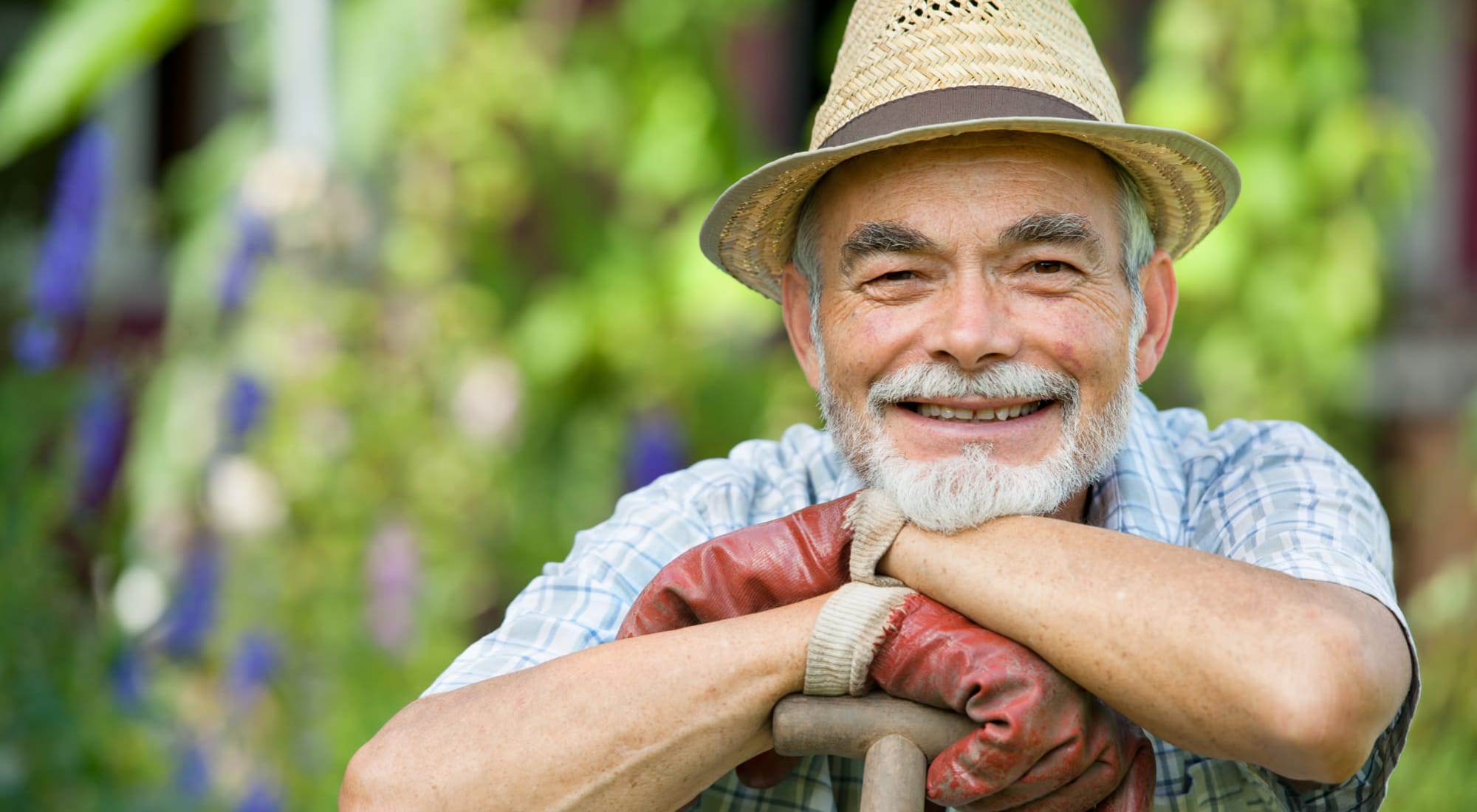 Smiling resident resting their hands on a shovel at Estoria Cooperative Lakeville in Lakeville, Minnesota