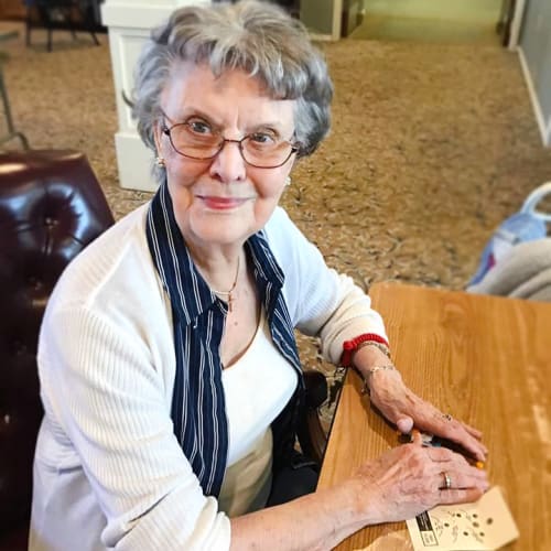 A resident sitting up to a table playing a game at Canoe Brook Assisted Living & Memory Care in Catoosa, Oklahoma