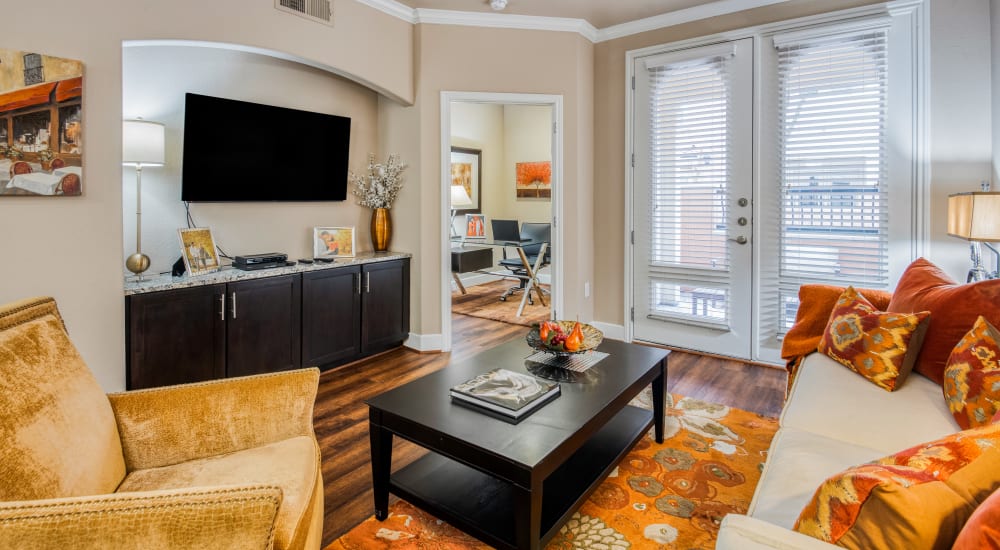 Leather couch and a comfortable chair in a model home's living space at Portico at West 8 Apartments in Houston, Texas