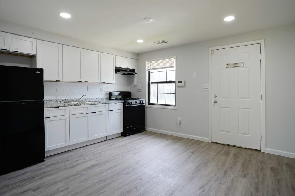 Modern kitchen with granite countertops, stainless steel appliances, and wood-style flooring at Dutch Village Apartments in Baltimore, Maryland