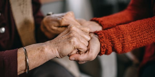 resident holding hands with a caretaker at a WISH location