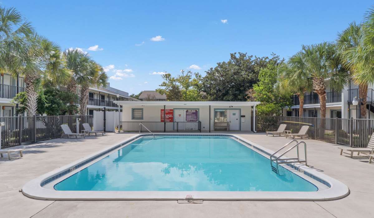 Sparkling pool surrounded by palm trees at Breeze Apartments in Gulf Breeze, Florida