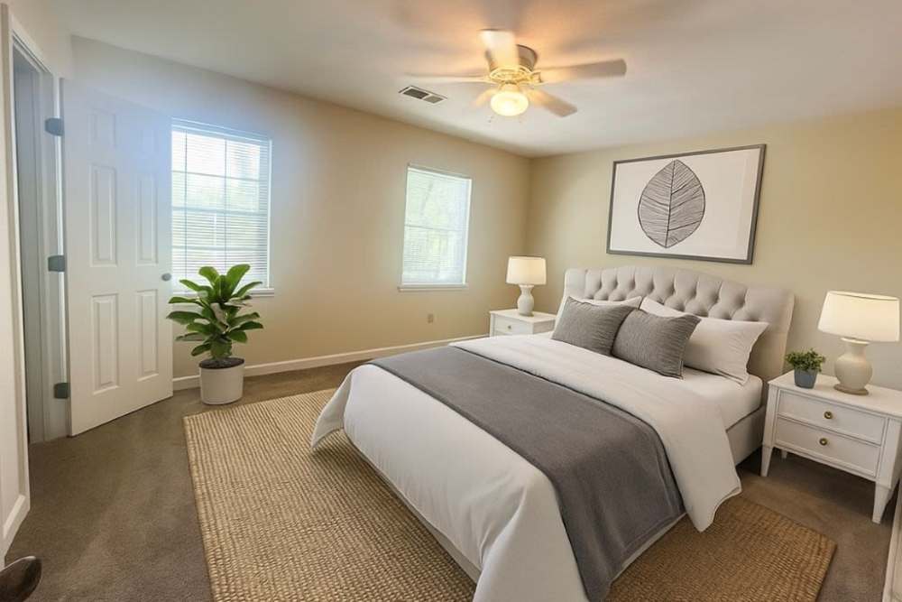 Bedroom with ceiling fan and carpet flooring at Crown Villa Apartments in Savannah, Georgia