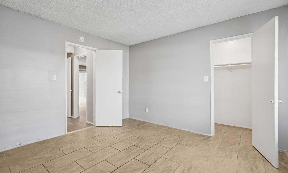Modern bedroom with attached closet at Newland Garden Apartments in Garden Grove, California