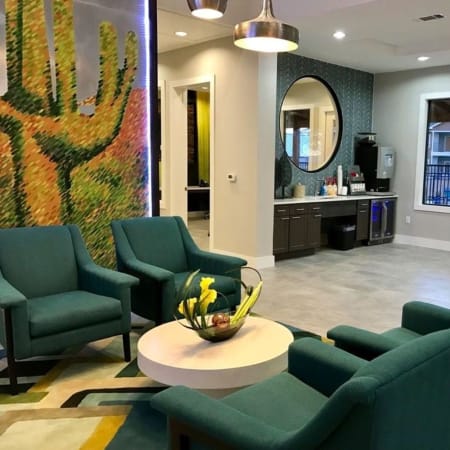 Sitting area with a cactus mural and coffee bar in the clubhouse at Creekside at Kenney's Fort in Round Rock, Texas