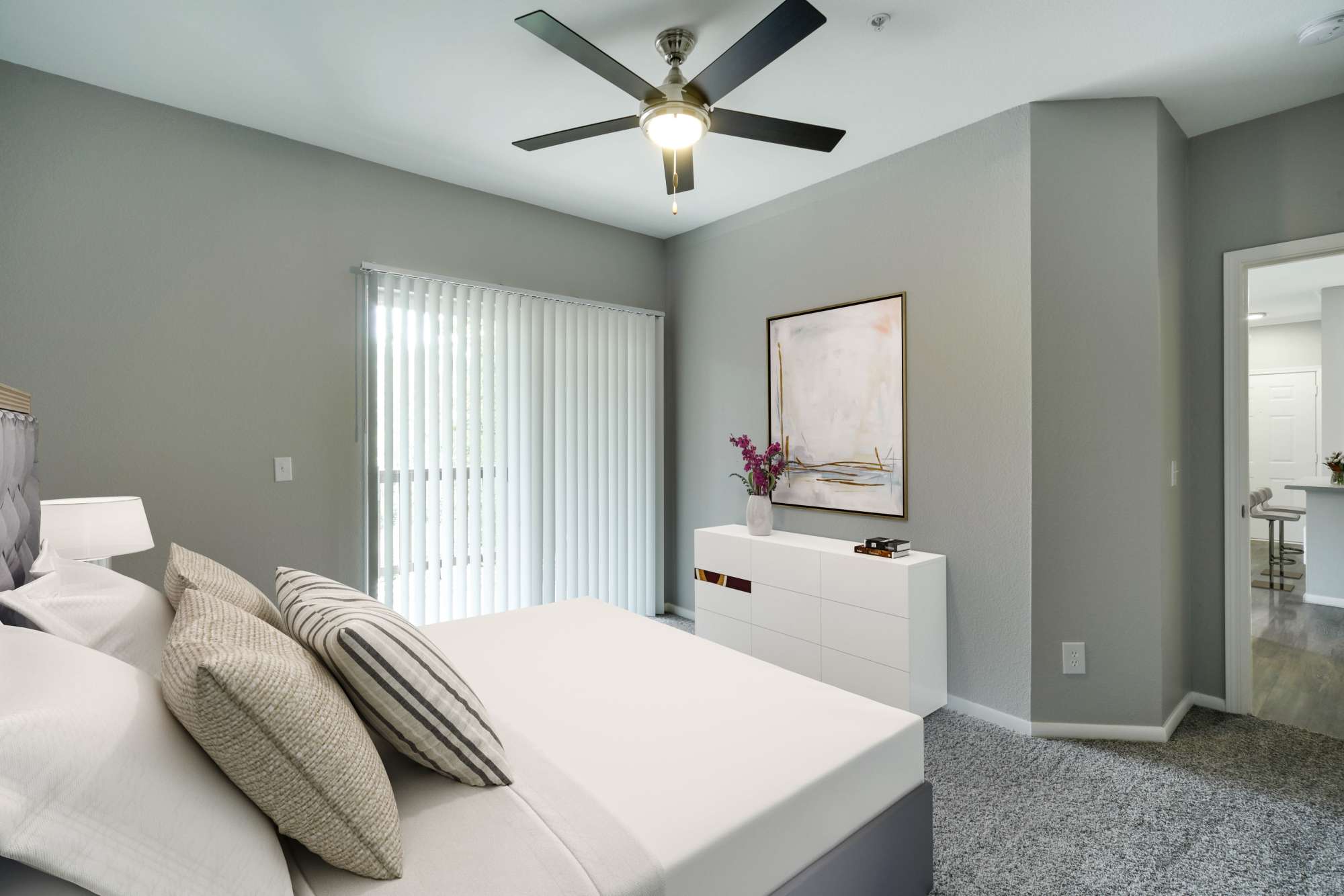 Bedroom with a large bed and ceiling fan at The Grove at Orenco Station in Hillsboro, Oregon