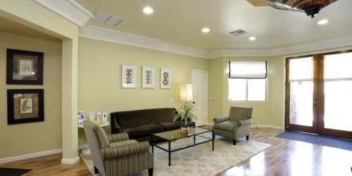 Stunning living room with good furniture and a black chandelier at Countryside Apartments in Poway, California