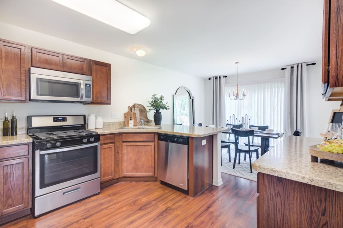 Apartment kitchen and dining area with wood-style flooring at The Manors at Brookmere in Matteson, Illinois