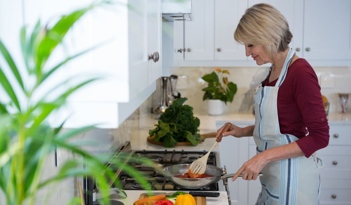 A resident prepares a meal in her kitchen at Acclaim at Cary Pointe, Cary, North Carolina