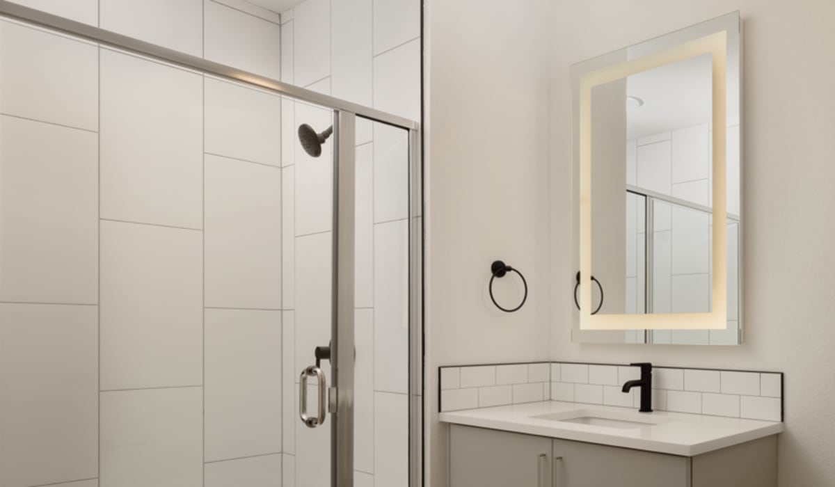 Bathroom with a large mirror and bathtub at Accent LoHi in Denver, Colorado