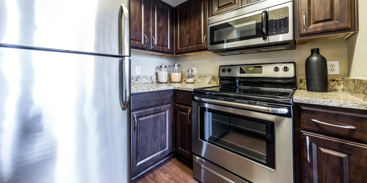 Modern kitchen with stainless steel appliances and granite counter tops at Marquis at Stonegate in Fort Worth, Texas