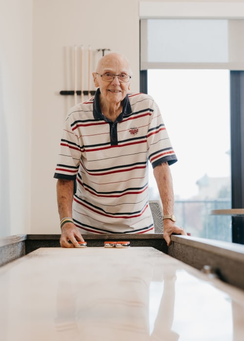 Old man playing shuffleboard at The Pillars of Lakeville in Lakeville, Minnesota