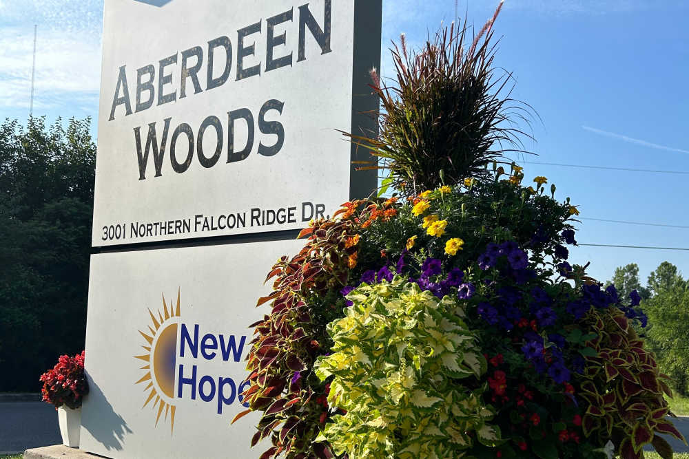 Vibrant flowers framing the Aberdeen Woods community sign at Aberdeen Woods in Jeffersonville, Indiana