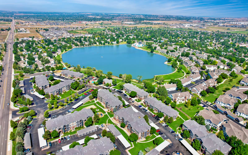 Aerial view of the property and nearby lake at Promenade at Hunter's Glen Apartments in Thornton, Colorado