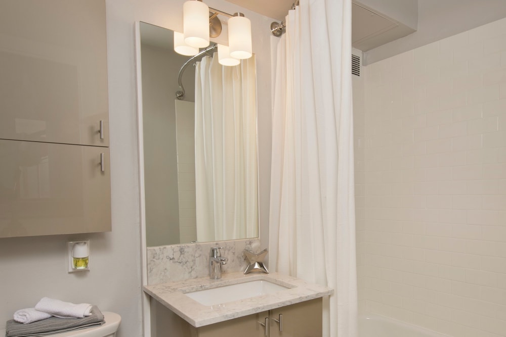 Bathroom with cabinet space and an oval tub at The Mill at First Hill in Seattle, Washington