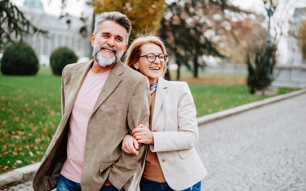 Couple walking together in a park, enjoying a leisurely afternoon outdoors at Alamitos on 4th in Long Beach, California 