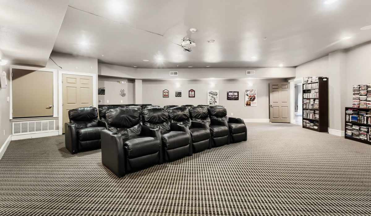 Cozy entertainment room with black recliner seating and movie posters on the walls at Lindbergh Parc Senior Apartments in Fort Worth, Texas