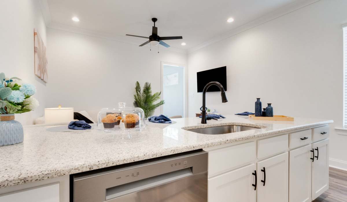 Bright kitchen with granite countertops, stainless steel appliances, and pendant lights, featuring wood-style flooring at Lakewood Villas in Bossier City, Louisiana