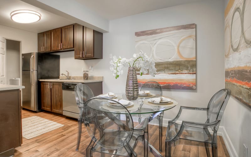 Renovated kitchen with brown cabinets leading into a dining room at Newport Crossing Apartments in Newcastle, Washington