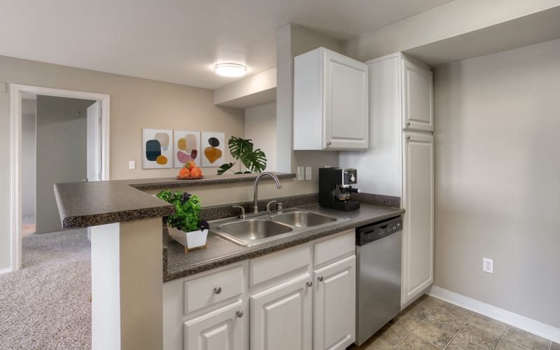 Renovated kitchen with white cabinets at Pebble Cove Apartments in Renton, Washington