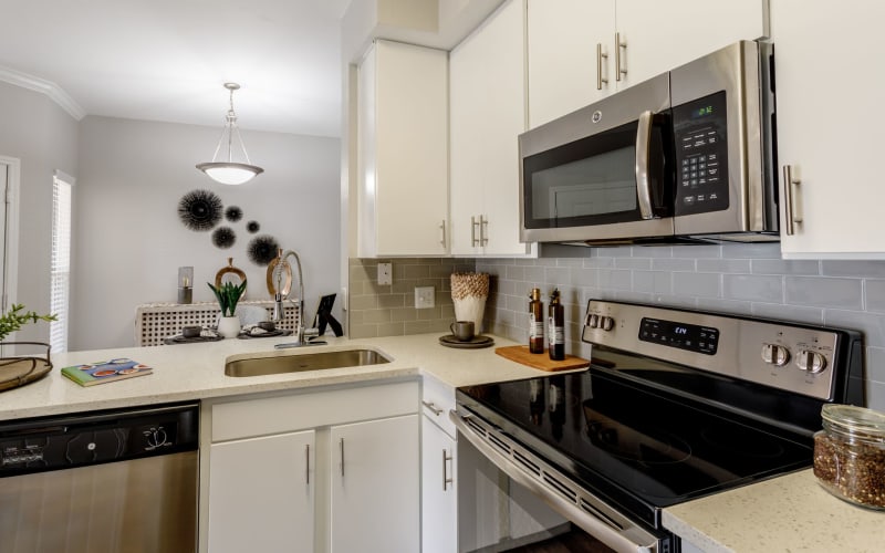 Kitchen with stylish gray backsplash overlooking the dining room at Altitude Westminster in Westminster, Colorado