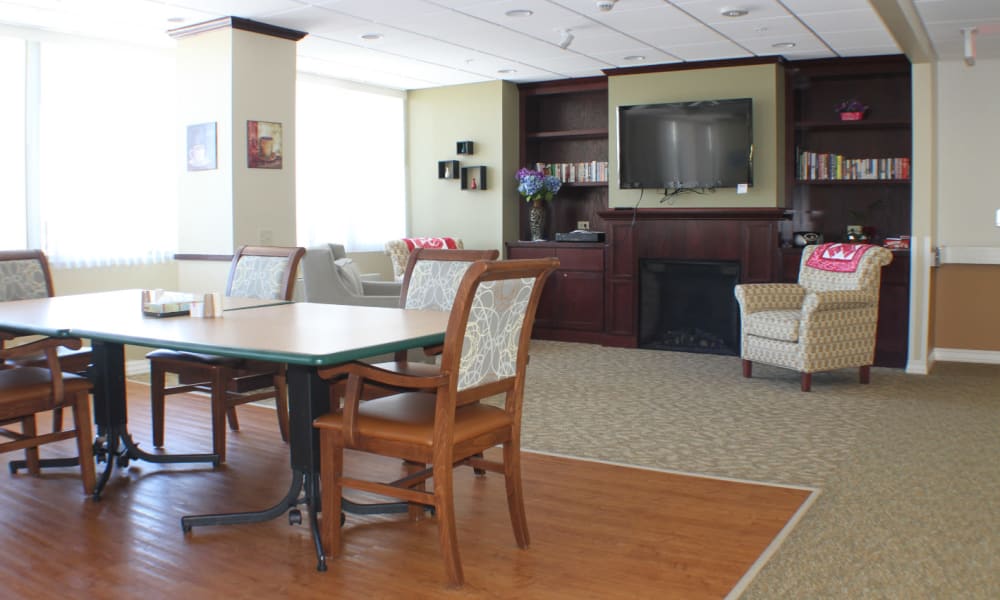 Media room with dining tables and television at Edgerton Care Center in Edgerton, Wisconsin