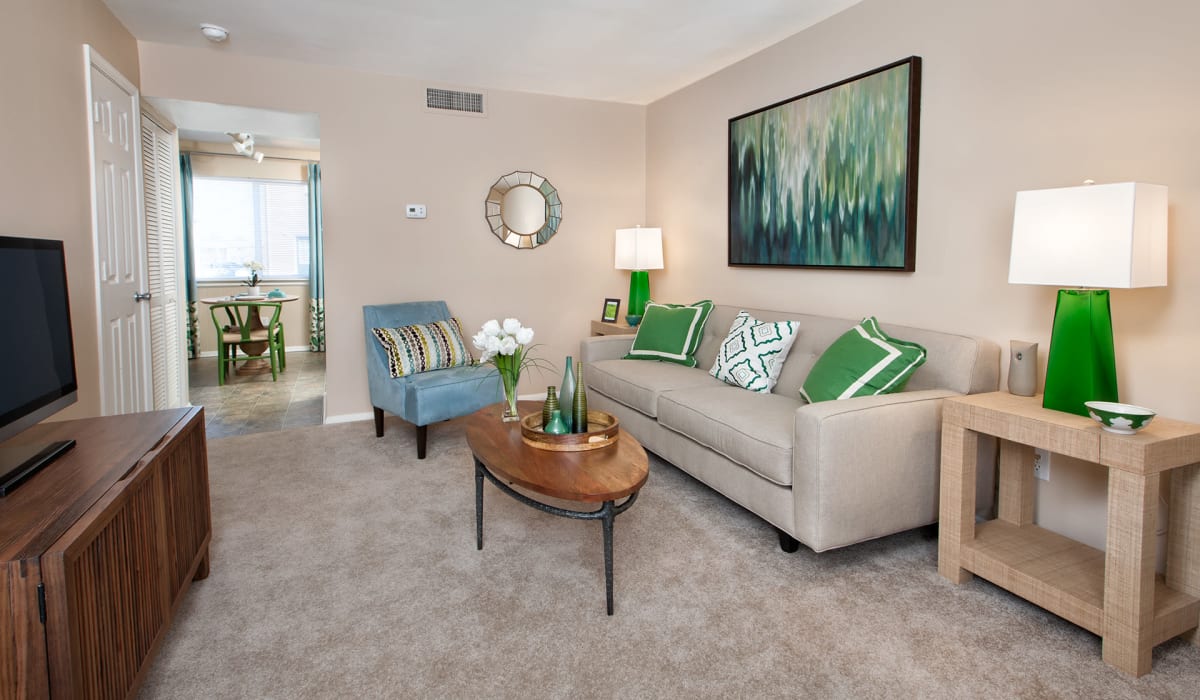 Spacious living room with wall-to-wall carpeting and neutral tones at James River Pointe in Richmond, Virginia